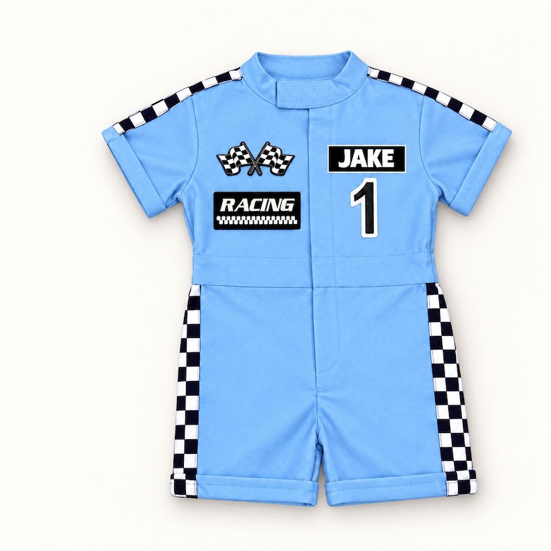 May include: A light blue short-sleeve romper featuring black and white checkered trim along the shoulders and sides. The front displays two crossed checkered flags, the text "RACING", the name "JAKE", and the number "1" in a bold black font.