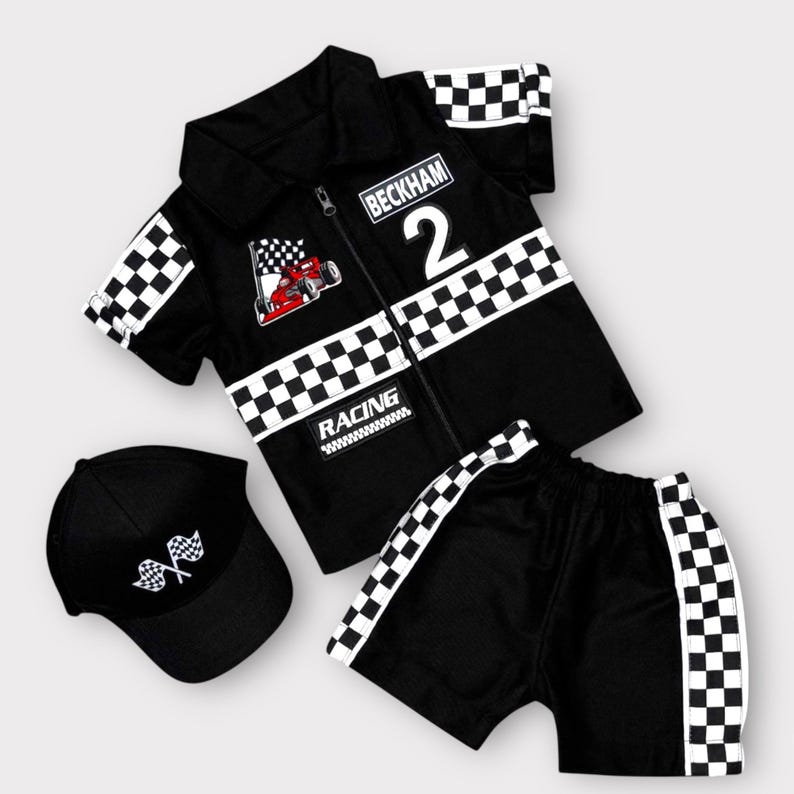 May include: A black short-sleeve collared shirt with a zipper, featuring a checkered pattern on the sleeves and midsection, a red race car graphic, the text "BECKHAM 2" and "RACING", matching black shorts with checkered side stripes, and a black cap.
