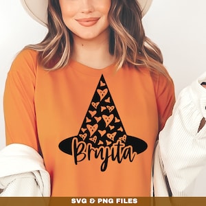Könnte beinhalten: Orangefarbenes Langarmshirt mit einem schwarzen Hexenhut-Design mit einem Muster aus Herzen und dem Namen "Bryjta" in einer Schreibschrift.