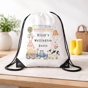 Puede incluir: Mochila con cordón blanca con una ilustración de granja, que incluye un cerdo, una cabra, una vaca y un tractor, y el texto "Riley's Wellington Boots". La bolsa tiene cordones negros y ojales metálicos.
