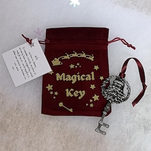Weihnachtsmann magisches Schlüsselgeschenk in einem schönen weinroten Samtbeutel mit einer personalisierten laminierten Karte, die an der Tasche angebracht ist. Weihnachtsabend Box Ideen.