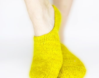 Puede incluir: Un par de calcetines amarillos y peludos. Los calcetines están hechos de un material suave y afelpado, ideales para mantener los pies calientes.