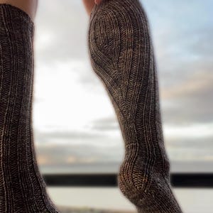 Könnte beinhalten: Ein Paar braune und schwarze Kniestrümpfe mit einem gerippten Strickmuster.