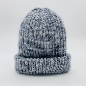 May include: A gray and white knit beanie with a ribbed texture.