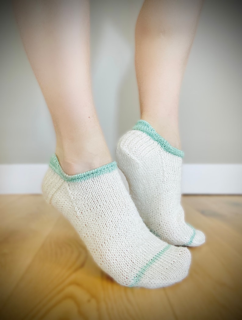 May include: A pair of white ankle socks with a light green trim. The socks are made of a soft, breathable material and are perfect for everyday wear.