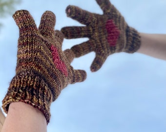 May include: A pair of brown and gold knitted gloves with red hearts on the back of the hands.