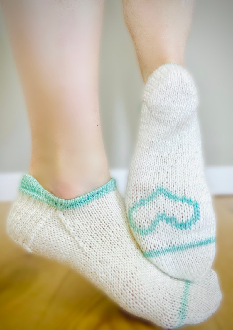 May include: A pair of white knitted socks with a light blue trim. One sock has a light blue infinity symbol design.