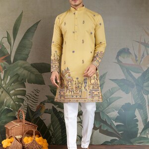 May include: A mustard yellow kurta with intricate embroidery on the cuffs and hem, paired with white trousers. The kurta features a mandarin collar and button-down front. The design includes floral and architectural motifs. The outfit is suitable for festive occasions.