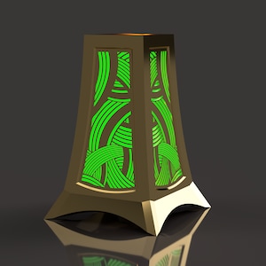 May include: A gold metal table lamp with a geometric green pattern. The lamp has a square base and a rectangular shade.