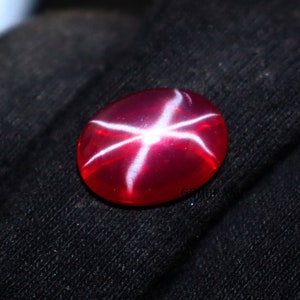 Peut inclure: Une pierre précieuse de rubis étoilé rouge avec un motif d'étoile blanche.