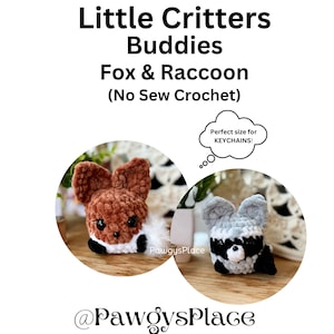 May include: Two crocheted stuffed animals, a fox and a raccoon, are sitting on a wooden surface. The fox is brown and white, and the raccoon is gray and black. The animals are small enough to be used as keychains. The text "Perfect size for KEYCHAINS!" is in a thought bubble above the animals.