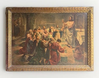 May include: A framed print depicting a religious scene with a central figure in robes holding a small object, surrounded by a group of kneeling and standing individuals in an interior setting with stone pillars, a table, and a large clay vessel.