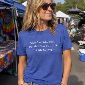 May include: A royal blue short-sleeved t-shirt featuring white text printed on the chest that reads, this has all been wonderful, but now i'm on my way. The shirt is made of a heathered fabric and has a crew neckline and a standard fit.