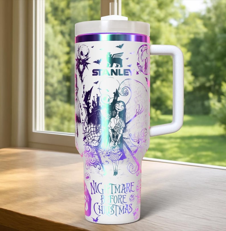 Puede incluir: Vaso t&eacute;rmico blanco con asa, con un dise&ntilde;o de "Pesadilla antes de Navidad". El dise&ntilde;o incluye a Jack Skellington, Sally y otros personajes en morado y negro. El vaso tiene una tapa blanca y un borde morado y plateado.
