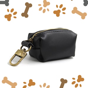May include: A black leather dog poo bag holder with a gold zipper and a gold metal clip.