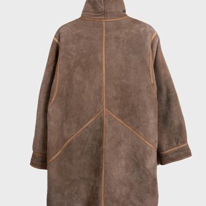 Get cozy in style with this vintage 80s shearling coat in brown. Its timeless design and soft warmth will have you feeling snug and stylish all season long. Don't miss out on this irresistible call to coziness!