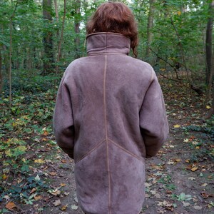 Get cozy in style with this vintage 80s shearling coat in brown. Its timeless design and soft warmth will have you feeling snug and stylish all season long. Don't miss out on this irresistible call to coziness!