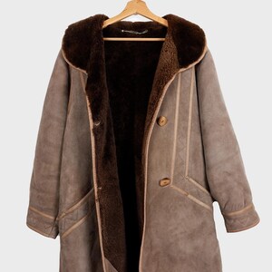 Get cozy in style with this vintage 80s shearling coat in brown. Its timeless design and soft warmth will have you feeling snug and stylish all season long. Don't miss out on this irresistible call to coziness!