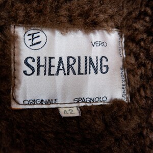 Get cozy in style with this vintage 80s shearling coat in brown. Its timeless design and soft warmth will have you feeling snug and stylish all season long. Don't miss out on this irresistible call to coziness!