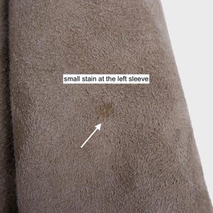Get cozy in style with this vintage 80s shearling coat in brown. Its timeless design and soft warmth will have you feeling snug and stylish all season long. Don't miss out on this irresistible call to coziness!