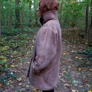 Get cozy in style with this vintage 80s shearling coat in brown. Its timeless design and soft warmth will have you feeling snug and stylish all season long. Don't miss out on this irresistible call to coziness!