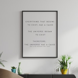 May include: A black framed print with a white background and black text that reads "Everything that begins to exist, has a cause. The universe began to exist. Therefore, the universe has a cause." The print is hanging on a white wall with a wooden paneling background.