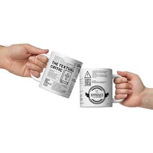 May include: Two white coffee mugs with black text and graphics. One mug features the text "The Textual Critic" with a cross and the text "Dead Sea Scrolls". The other mug features the text "Approved by the Greek Orthodox Church" with a seal.