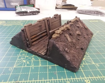 May include: A detailed model of a World War I trench, featuring wooden planks, sandbags, and rusty metal pipes. The trench is painted in earthy tones, creating a realistic and gritty look.