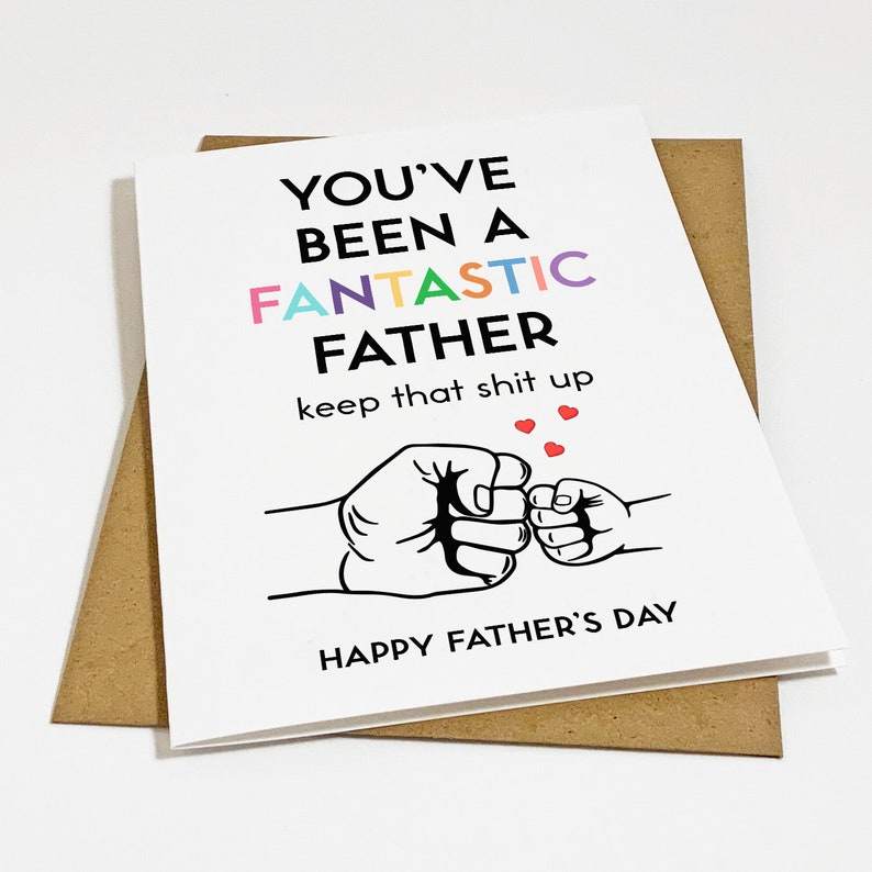 May include: A Father's Day card with a white background and black text that reads "You've Been a Fantastic Father keep that shit up". The text "Fantastic" is in rainbow colors. The card also features a black and white illustration of two fists bumping, one larger than the other, with three red hearts above them. The text "Happy Father's Day" is at the bottom of the card.
