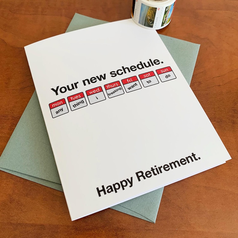 May include: A white card with the text "Your new schedule." and a calendar graphic with the days of the week. The calendar graphic has the following text: "Mon any", "Tues thing", "Wed 1", "Thurs freaking", "Fri want", "Sat to", "Sun do". The card also has the text "Happy Retirement." at the bottom.