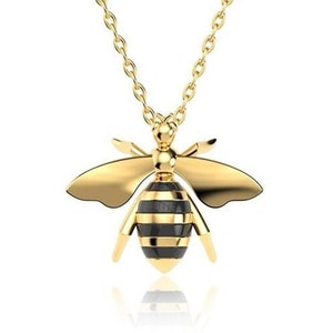 May include: A gold bee pendant necklace with black and gold striped detailing. The bee is detailed with wings and legs.