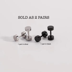 May include: Two pairs of stainless steel earrings, one pair in silver and one pair in black.  The earrings are shaped like dumbbells.  Sold as 2 pairs.