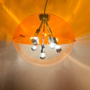 May include: A modern, orange and white, half-sphere pendant light fixture with five light bulbs.