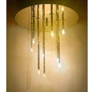 May include: A gold-toned chandelier with multiple hanging light bulbs. The chandelier has a circular base and is suspended from the ceiling.