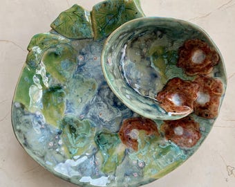 Handgemaakte keramische schaal voor chips en dipsaus: gebeeldhouwde bladeren, bloemen en blauwgroene glazuren.