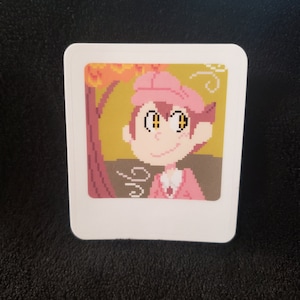 May include: A pixel art sticker of a cartoon character with pink hair, a pink hat, and yellow eyes. The character is wearing a pink shirt and is standing in front of a brown tree with orange leaves.