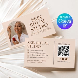 May include: Business cards for Skin Ritual Studio. The cards are a light beige color with the studio's name in brown text. One card features a photo of a person applying skincare. The other card includes contact information and a QR code.