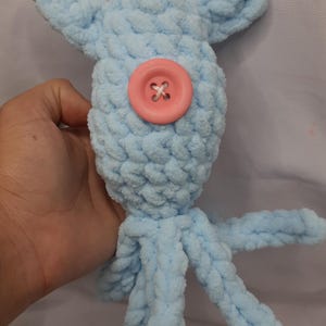 May include: A light blue crocheted octopus toy with a pink button for an eye.