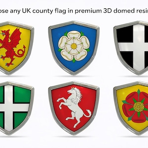 Könnte beinhalten: Sechs 3D-gewölbte Resin-Schilde mit Designs von britischen County-Flaggen. Die Schilde haben einen silbernen Rand und zeigen verschiedene Embleme, darunter einen roten Drachen, eine weiße Rose und ein weißes Kreuz. Der Text "Wählen Sie eine beliebige britische County-Flagge in einem Premium 3D-gewölbten Resin-Schild" steht oben.