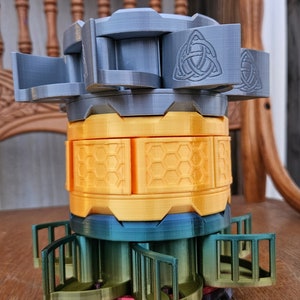 May include: A multi-layered, 3D printed, rotating puzzle box with a honeycomb pattern, a green and blue gradient, and a gray top with a Celtic knot design.