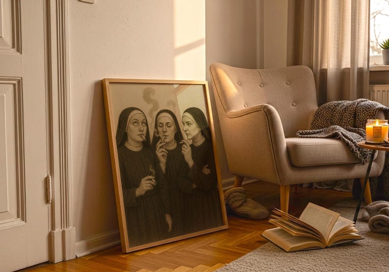 Puede incluir: Una obra de arte enmarcada representa a tres monjas fumando cigarrillos. Las monjas visten h&aacute;bitos negros y tocas blancas. La obra est&aacute; apoyada contra una pared junto a un sill&oacute;n beige y una mesita auxiliar.