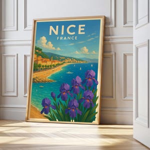 Könnte beinhalten: Gerahmter Kunstdruck mit einer malerischen Ansicht von Nizza, Frankreich, mit Küstenlinie, blauem Meer und lila Iris im Vordergrund. Der Druck trägt oben das Wort "NICE".