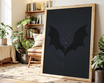 Könnte beinhalten: Ein gerahmter Kunstdruck mit einem dunkelblauen Sternenhintergrund und schwarzen Fledermausflügeln. Das Kunstwerk wird in einem Raum mit Pflanzen und Holzboden ausgestellt. Der Rahmen ist aus Holz.