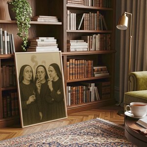 Puede incluir: Una obra de arte enmarcada representa a tres monjas fumando cigarrillos, con humo ascendente. La imagen est&aacute; ambientada en una habitaci&oacute;n con una estanter&iacute;a de madera llena de libros, un sill&oacute;n verde y una alfombra estampada. Tambi&eacute;n se ven una l&aacute;mpara dorada y una taza de t&eacute;.