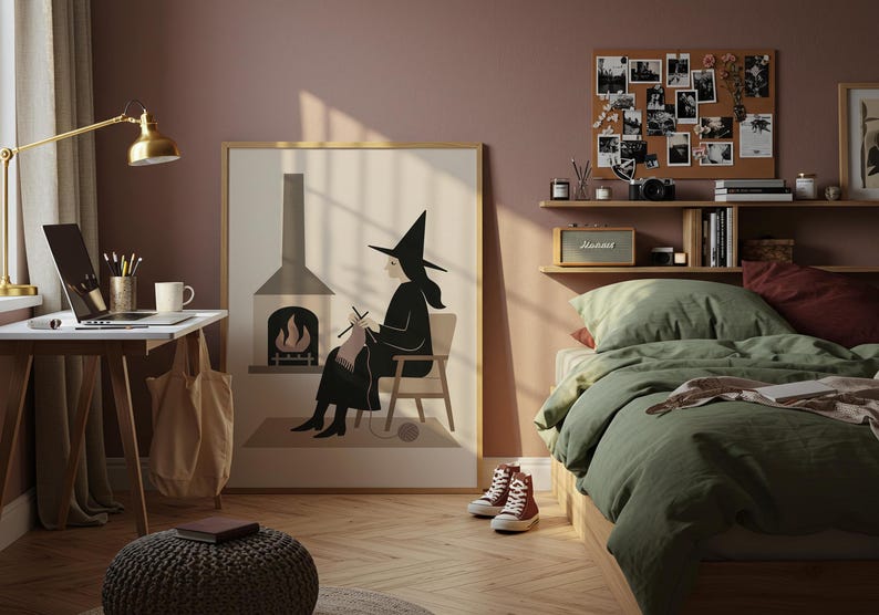 Op de afbeelding: Een slaapkamerinterieur met een ingelijste print van een breiende heks. De kamer heeft een bureau met een laptop, een bed met groen beddengoed en een prikbord met foto's. Rode sneakers staan op de houten vloer.