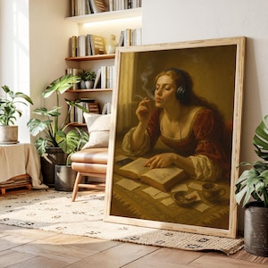 May include: A framed print depicting a woman in a red dress, wearing headphones, smoking a cigarette, and reading a book. The artwork has a vintage style, with a warm colour palette and a wooden frame. A cup and ashtray are on the table.