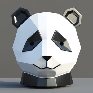Puede incluir: Una escultura de cabeza de panda geométrica blanca y negra con una base negra. El panda tiene un diseño simple y estilizado con ojos negros y una pequeña nariz negra.