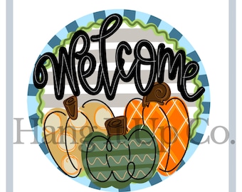 May include: A round welcome sign with a blue, green, and gray striped background. The word "welcome" is written in black cursive lettering. Three pumpkins are in the bottom half of the sign, one is orange with a diamond pattern, one is yellow with white polka dots, and one is green with a wavy pattern.