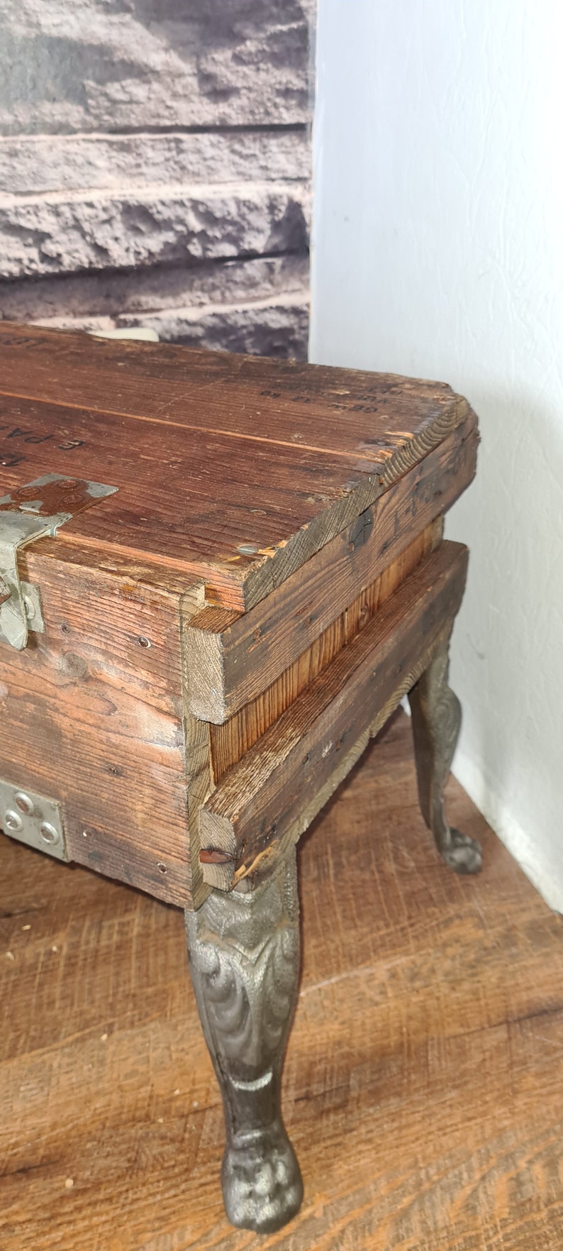 May include: A wooden box with metal hardware and decorative cast iron legs. The box is made of reclaimed wood and has a rustic look.