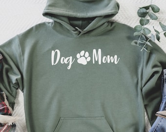 Könnte beinhalten: Ein grüner Kapuzenpullover mit einem weißen Pfotenabdruck und dem Text "Dog Mom" auf der Vorderseite.